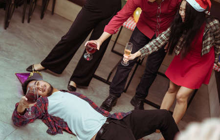 Men hang and drunk sleeping after drinking wine in x'mas party with friend group together danceの写真素材