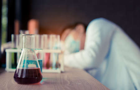 Scientist man with glasses reserch and conducts experiments by synthesising compounds in laboratory and the test tube, Sleeping, problem, worrying after workの写真素材