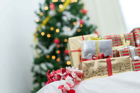Many Gift box surprise luxury on bed and christmas tree background at home celebrate, Christmas holiday concept.の写真素材