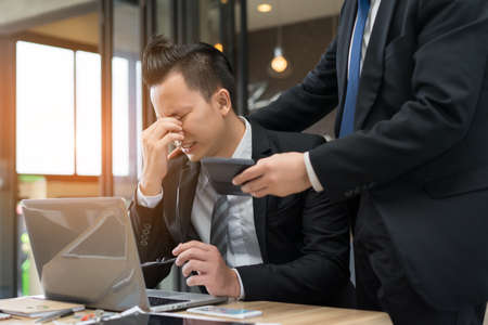 Businessmen with glasses together serious problem fail, tired hard project of daily sale report with laptop computer.の写真素材