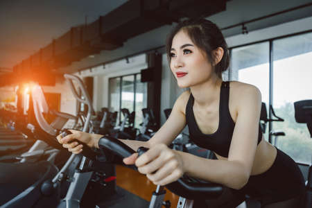 Young asian woman exercise cardio workout on treadmill machine and healthy lifestyle bodybuilding at fitness gym.の写真素材