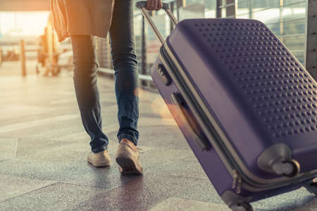 Traveler with suitcase in airport concept.Young girl  walking with carrying luggage and passenger for tour travel booking ticket flight at international vacation time in holiday rest and relaxation.の写真素材