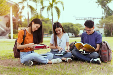 Students young asian together reading book study smiling with tablet,laptop computer at university...