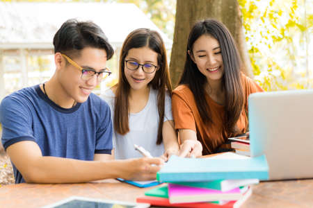 Students helping friend consult,totor,teamwork working hard exam study in university campus or high school education with technology knowledge on table meeting togetherの写真素材