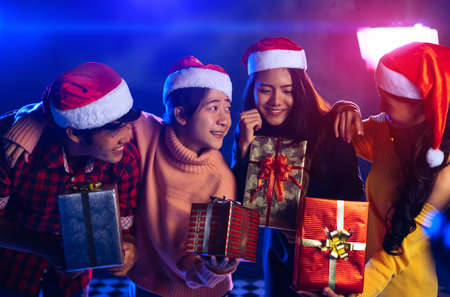 Friends together celebrating christmas party with gift box surprise for new year eve happiness and enjoy in pub midnightの写真素材