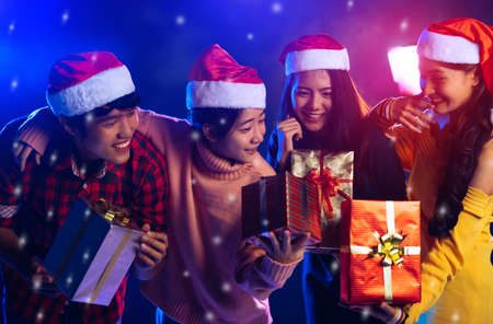 Friends together celebrating christmas party with gift box surprise for new year eve happiness and enjoy in pub midnightの写真素材