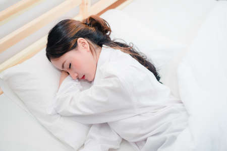 Beautiful asian woman sleeping on bed under blanket at room in the morning healthy lifestyleの写真素材