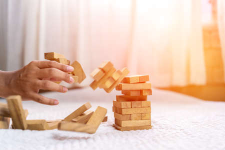 Hand of pulling wood block fail on building tower at home and drape change, choice business risking dangerous project plan failure construction,Selective block woodenの写真素材