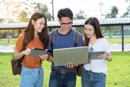 Students university asian together study smiling with tablet,laptop computer at university high school campus,college in summer holiday relaxationの写真素材