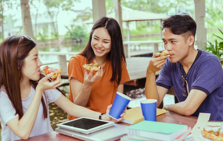 Asian group together eating pizza in breaking time having fun and enjoy party italian food slice with cheese delicious の写真素材