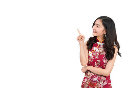Asian woman wearing chinese dress,cheongsam,qipao finger gesture present and show something on copy space white isolated background and smileの写真素材