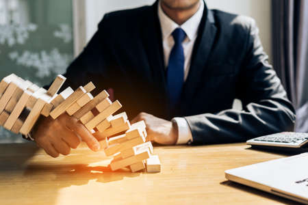Businessman fail danger tower challenge game building consturction protect plan and project for control risk shape with paperworkの写真素材