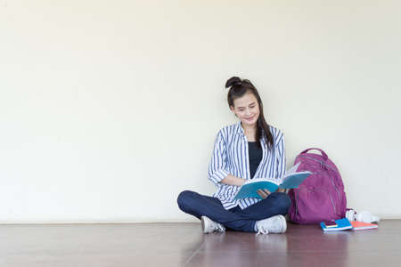 Student teenage reading book study,learning at university campus indoor sitting and smile relaxing, copy space background lifestyle people in high school conceptの写真素材