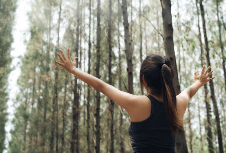 Woman sport resting and relax in the forest after runner workout her having enjoy freedom active healthy lifestyle stretching on summer.の写真素材
