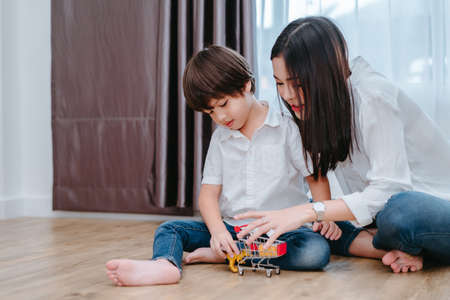 Mother playing with son preschool education with toy and cart in the morning at home for kindergarten lessen.の写真素材