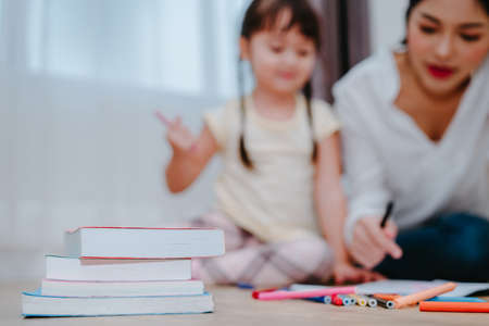 Mother and daughter study drawing with crayon paint on the paper family lifestyle, preschool and kindergarten education at home.の写真素材