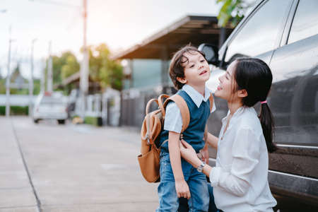 Mother dressing up a son and sending to school, Parent and pupil going to kindergarten of preschool first day.の写真素材