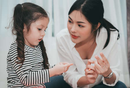 Mother teach daughter counting numbers finger, Parent and kid education preschool or kindergarten tutor at home family lifestyle.の写真素材