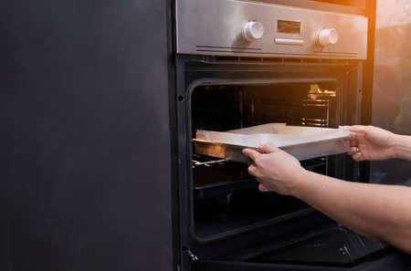 Closeup hands holding homemade bakery bread with microwave oven preparing breakfast food snack delicious in kitchenの写真素材