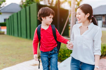Mother get a son pupil from school after study school back to home with schoolbag family lifestyle.の写真素材