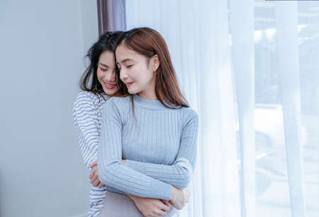 Same sex asian lesbian couple lover embrace in the bedroom at morning happiness feeling, LGBT sexuality female hug living together at home.の写真素材