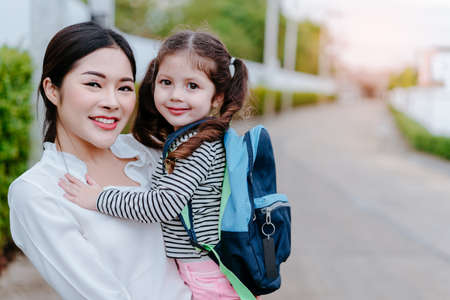Mother and daughter pupil portrait back to school student concept at village with schoolbag family lifestyle.の写真素材