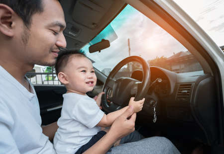Asian Little son driving car with father for going travel, happy family leisure in holiday weekend.の写真素材