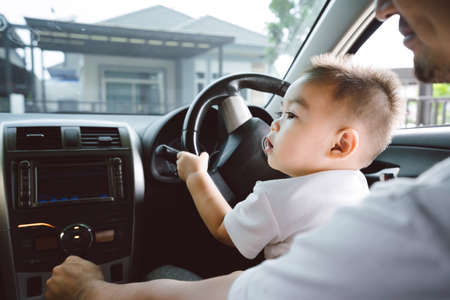 Little boy driving car with father for going travel, happy family leisure in holiday weekend, Soft focus.の写真素材