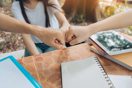 Closeup students fist bump education success concept, Asian study team together successful plan and...