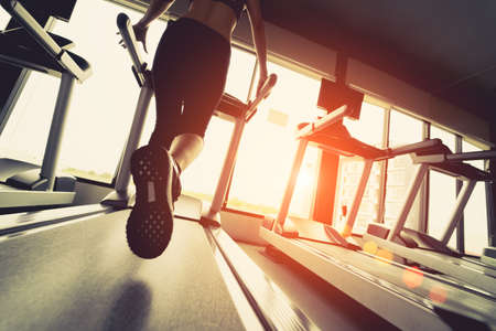 Exercise treadmill cardio running workout at fitness gym of woman taking weight loss with machine...