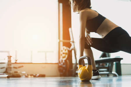 Woman exercise workout at gym fitness training sport with kettlebells weight lifting and legs squat healthy lifestyle bodybuilding.の写真素材