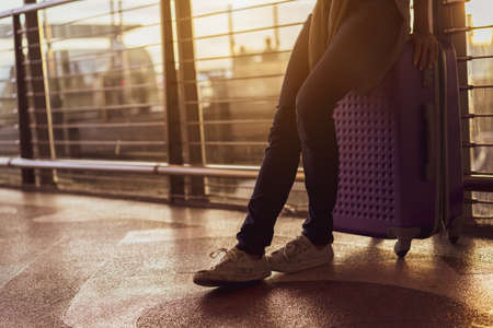 Woman traveler waiting airplane after booking ticket flight at airport with carrying,backpack,suitcase luggage for tranport travel international vacation time in holiday relaxation.の写真素材
