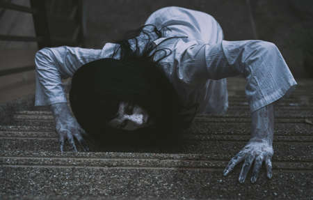 Ghost Woman Horror scene Death movie with Halloween Makeup clamber on Ladder in Abandoned house.の写真素材