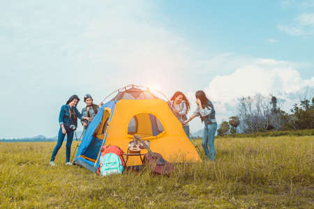 Group of Young Asian women helping build a tent for  rest at lake river camping vacation time on weekend travel people lifestyle.の写真素材