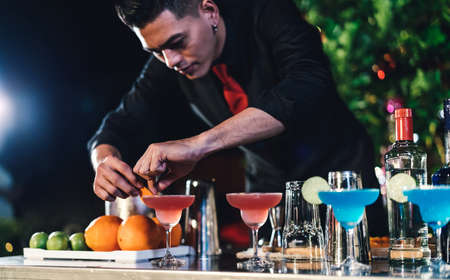 Professional asian male bartender prepare mixing cocktail drink at village night party celebration, Extra work job service customer outdoor people lifestyle.の写真素材