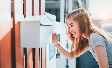Beautiful asian woman open letter box checking at front home, Delivery message bills order receive...