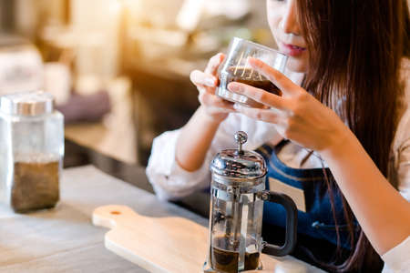 Professional Asian woman Barista preparing coffee at front counter serving coffee cup to customer occupation, part-time, job or owner business working woman happy selling and making drink beverageの写真素材
