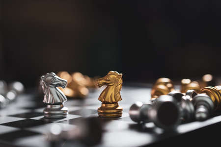 Gold and Silver Chess game knight staying on chessboard, Business planing strong concept with black backgroundの写真素材
