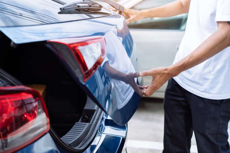 Man open hatchback car for trunk cardboard box parcel delivery transportation technology system convenient, Vehicle and  automotive travel road trip in the holiday lifestyle on summer vacation conceptの写真素材