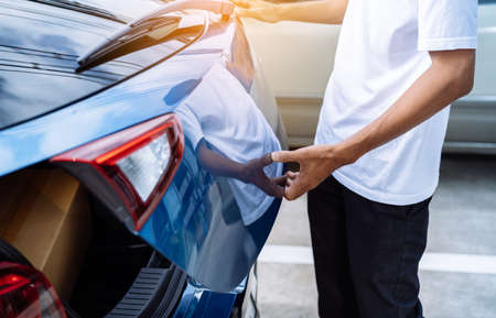 Man open hatchback car for trunk cardboard box parcel delivery transportation technology system convenient, Vehicle and  automotive travel road trip in the holiday lifestyle on summer vacation conceptの写真素材