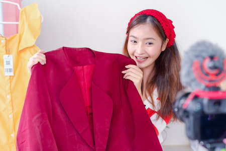 Beautiful young Asian woman vlogger blogging presentation clothing fashion video live social media recording her selling online via digital camera, Owner small business entrepreneur people lifestyleの写真素材