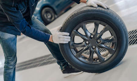 Mechanic man change a wheel tyre and service maintenance the suspension of a vehicle , Safety inspection test engine before customer drive a car on a long journey, transportation serviceの写真素材
