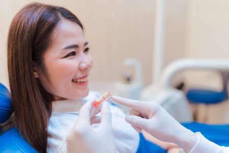 Woman having dental teeth examined dentist check-up with implant false tooth in Clinic her patient for beautiful smileの写真素材