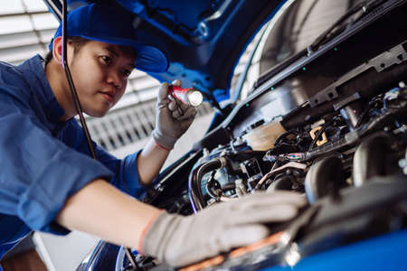 Mechanic man examining and maintenance to customer the engine a vehicle car hood, Safety inspection test engine before customer drive on a long journey, transportation repair service centerの写真素材