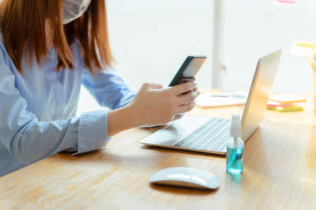 Asian woman wearing mask staying at home playing smartphone relaxing emotion, Prevent the spread of...
