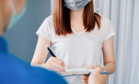 Door to door delivery express sending send a package wearing mask to customer receiver sign checking shipping deliver cargo prevention infection quarantine while the virus is spreading, Coronavirus.の写真素材