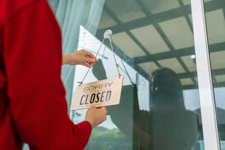 Woman closed store with sign board front door shop, Small business come back turning agian after the situation is resolved.の写真素材