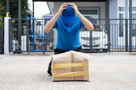 Delivery man Frightened with cardboard box damaged broken accident before delivering to customers at home, Express service client online shopping comfortable payment package product.の写真素材