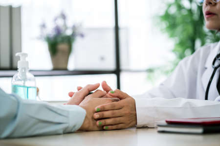 Mental Health: Close-up shot of male doctor filling in medical record, Professional medical doctor consulting her patient at hospital, Healthcare conceptの写真素材