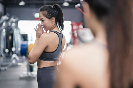 Sporty young asian women with friends taking picture of her friend using mobile phone, Females having fun in gym, Sportive fitness training exercise and healthy lifestyle concept.の写真素材